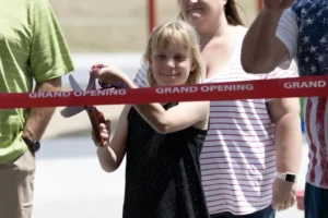 girl cutting ribbon for Mendon Splash Park